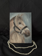 Oil Painting of a horse with a bridle on a black background with pearls.