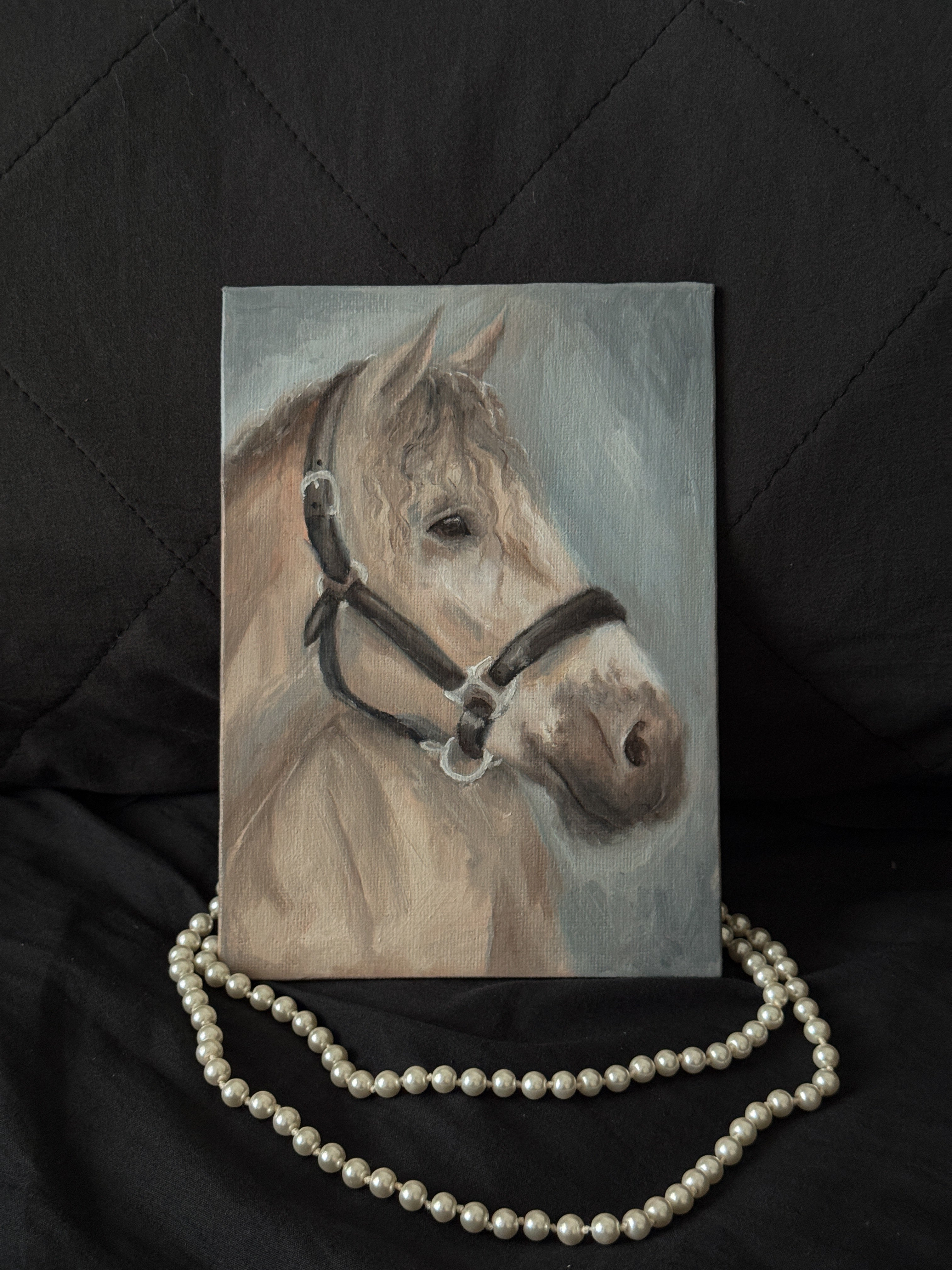 Oil Painting of a horse with a bridle on a black background with pearls.