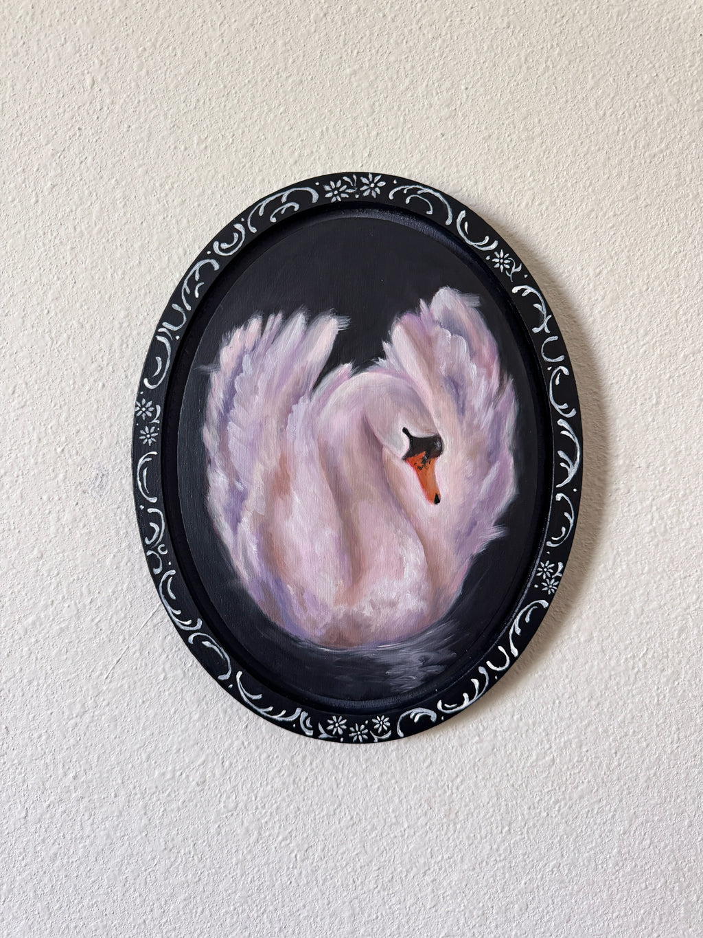 oil painting of a swan with an ornamental border on a white wall
