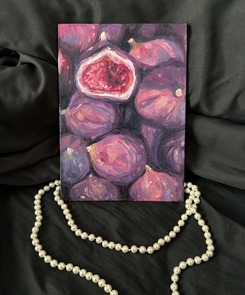 Oil Painting of figs against a black background with a pearl necklace